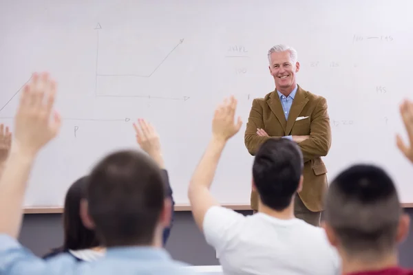 Portrait of in teacher in classroom with students — Stock Photo, Image