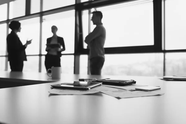 Primer plano de la tableta, gente de negocios en la reunión en segundo plano — Foto de Stock