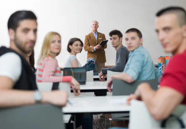 Retrato de em professor em sala de aula com alunos — Fotografia de Stock