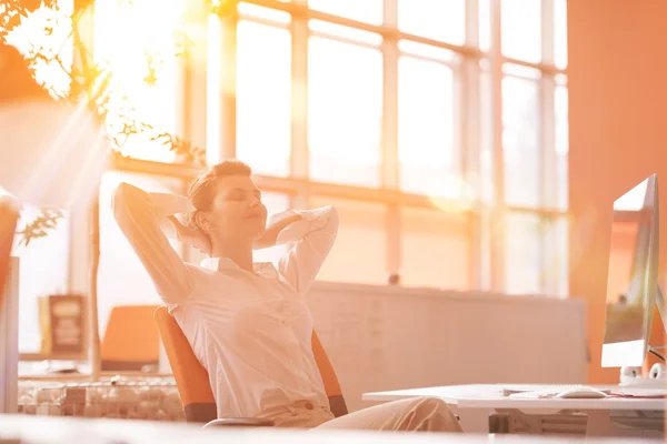 Jovem empresária relaxante no local de trabalho — Fotografia de Stock