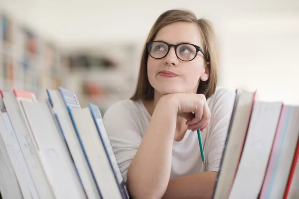Porträt einer Studentin, die Buch in der Bibliothek liest — Stockfoto