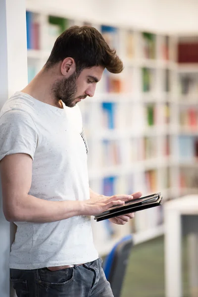 Estudiante en la biblioteca de la escuela usando tableta para la investigación —  Fotos de Stock