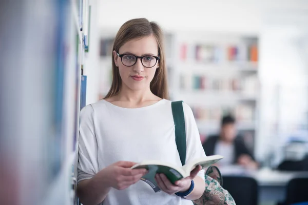 Portrait of female student reading book in library — Stock Photo, Image