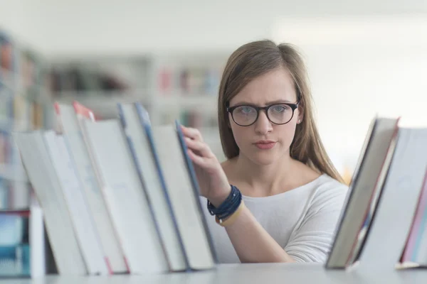 Ritratto di studentessa che legge libro in biblioteca — Foto Stock