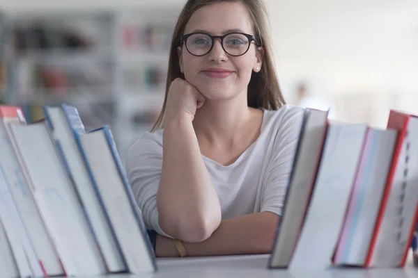 Portret van vrouwelijke student leesboek in bibliotheek — Stockfoto