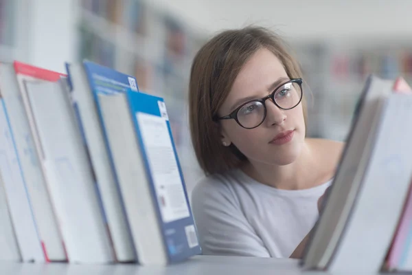 Ritratto di studentessa che legge libro in biblioteca — Foto Stock
