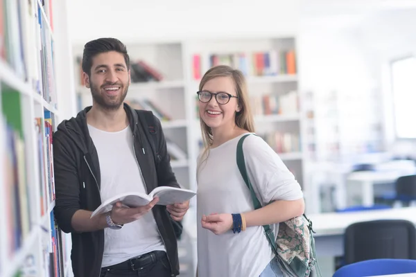 Estudantes casal na biblioteca da escola — Fotografia de Stock