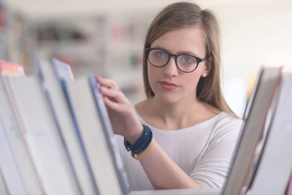 Portrait of female student reading book in library — Stock Photo, Image