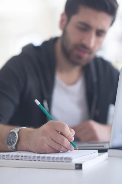 Estudiante en la biblioteca de la escuela usando el ordenador portátil para investigación — Foto de Stock