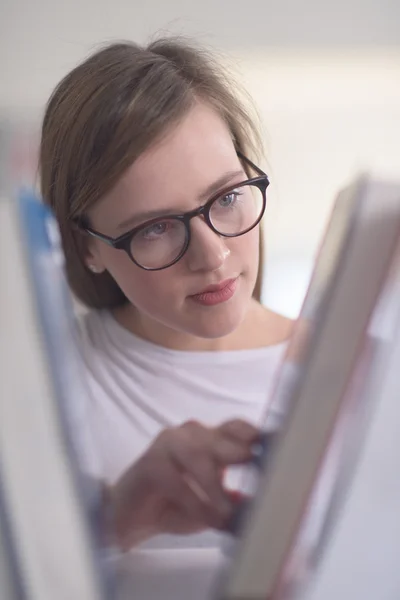 Portrait of female student reading book in library — Stock Photo, Image