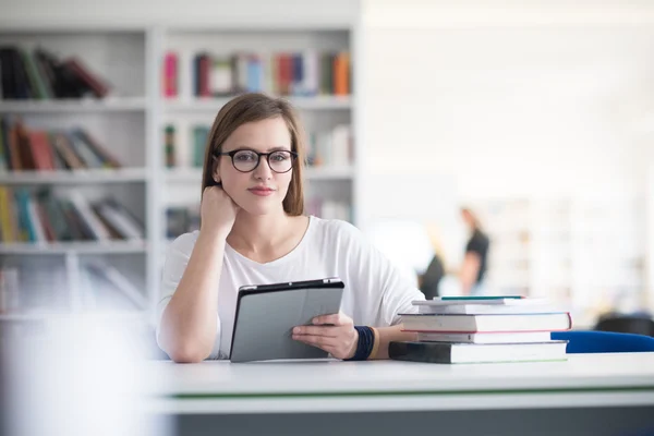 Kobiece student studium w szkolnej bibliotece, za pomocą tabletu — Zdjęcie stockowe