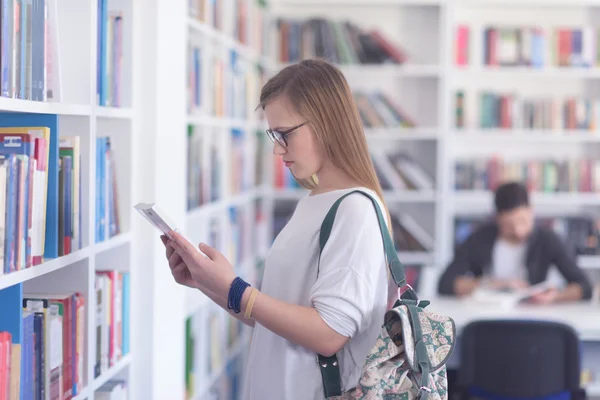 Famale student selecting book to read in library — Stock Photo, Image