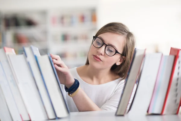 Portrét studentka čtení knihy v knihovně — Stock fotografie