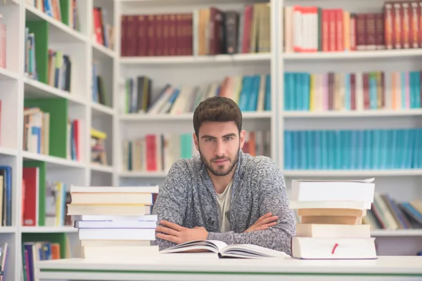 Student při čtení knih ve školní knihovně — Stock fotografie