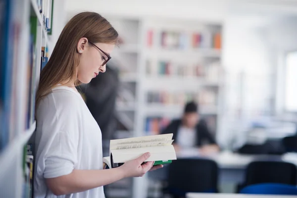 Retrato de una estudiante leyendo un libro en la biblioteca — Foto de Stock