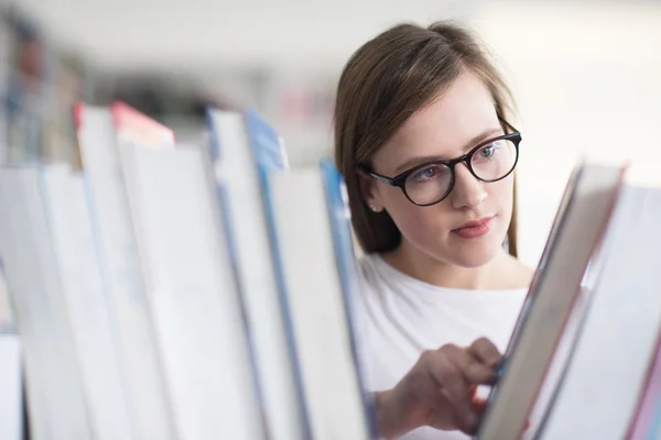 Portrait of female student reading book in library Royalty Free Stock Photos
