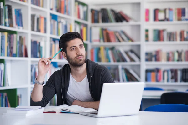 Uczeń w szkole biblioteki za pomocą laptopa do badań — Zdjęcie stockowe