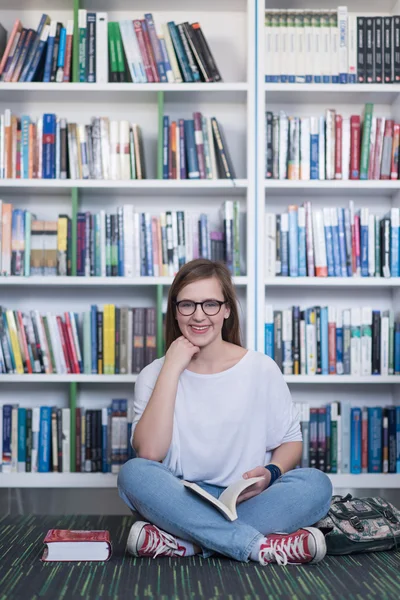 Famale student leesboek in bibliotheek — Stockfoto