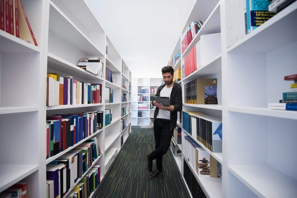 Student met tablet in bibliotheek — Stockfoto