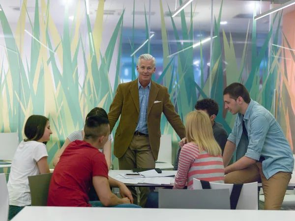 Portrait of in teacher in classroom with students — Stock Photo, Image