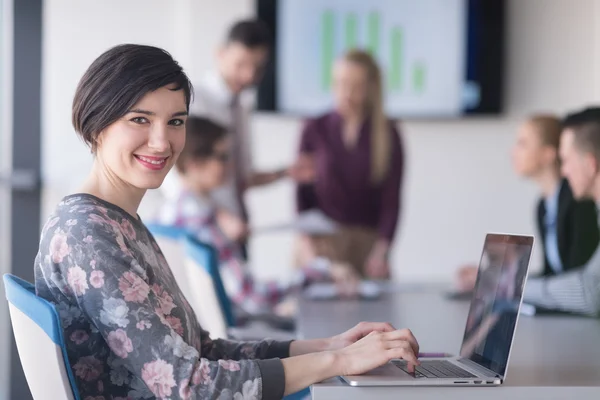 Ung affärskvinna på kontoret arbetar på laptop med team på mig — Stockfoto