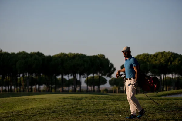 Golfspelare promenader och golf väska i vackra solnedgången — Stockfoto