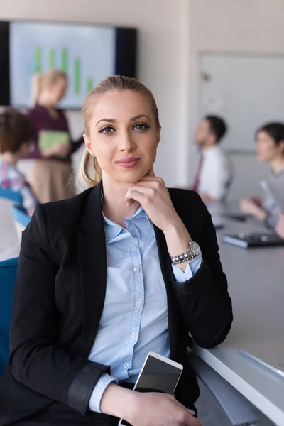 Portret van jonge zakenvrouw op kantoor met team op vergadering — Stockfoto