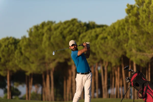 Golfista golpeando un tiro bunker de arena en la puesta del sol — Foto de Stock