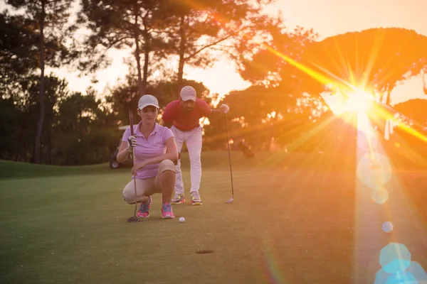 Pár na golfovém hřišti při západu slunce — Stock fotografie