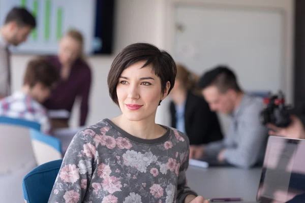 Portret van jonge zakenvrouw op kantoor met team op vergadering — Stockfoto