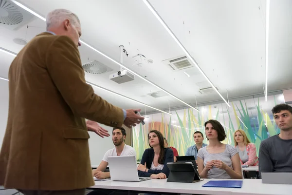 Lärare med en grupp elever i klassrummet — Stockfoto