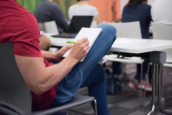 Estudante do sexo masculino tomar notas em sala de aula — Fotografia de Stock