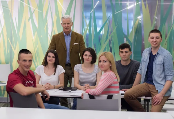 Portrait of  teacher with students group in background — Stock Photo, Image