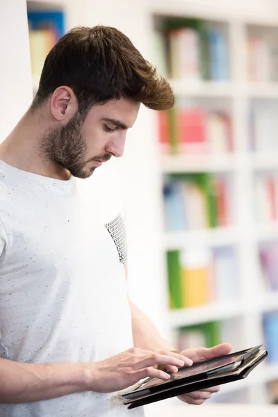 Student ve školní knihovně pomocí tabletu pro výzkum — Stock fotografie