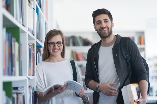 Paar van de studenten in de schoolbibliotheek — Stockfoto