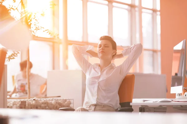 Jovem empresária relaxante no local de trabalho — Fotografia de Stock