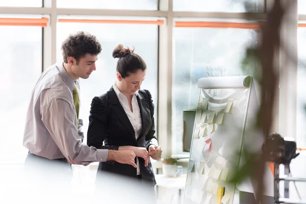 Ungt par arbetar på flip board på kontor — Stockfoto