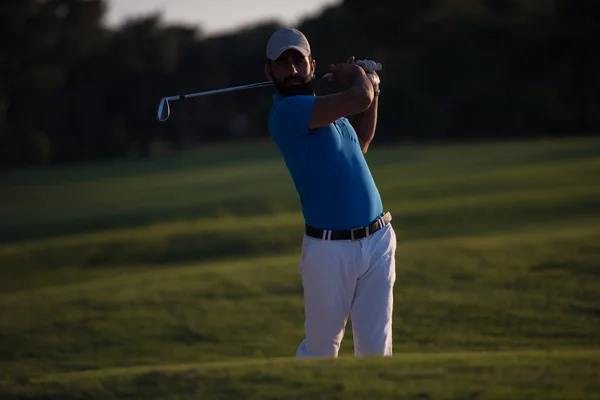 Golfista golpeando un tiro bunker de arena en la puesta del sol — Foto de Stock