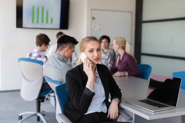 Wanita bisnis berbicara di telepon di kantor dengan tim pada pertemuan — Stok Foto