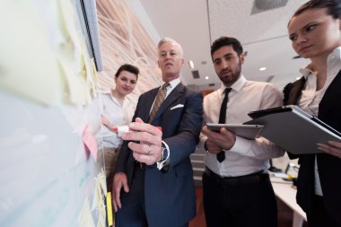 iş adamları grup beyin fırtınası ve flipboar için not alma