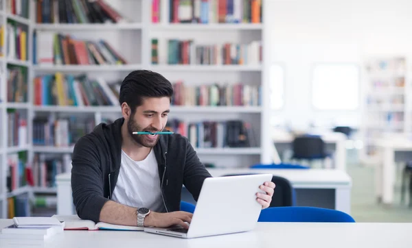 Estudante na biblioteca da escola usando laptop para pesquisa — Fotografia de Stock