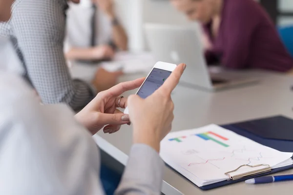 Close up van busineswoman handen met behulp van slimme telefoon over de bijeenkomst van — Stockfoto