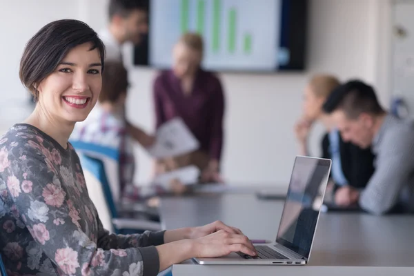 Giovane donna d'affari in ufficio che lavora su laptop con team su di me — Foto Stock