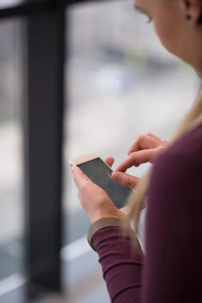 Affärskvinna med smart telefon på kontoret — Stockfoto