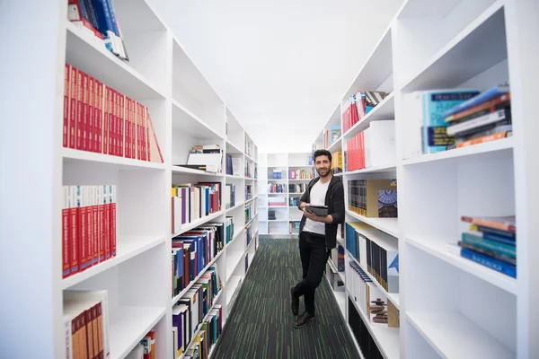 Estudante com tablet na biblioteca — Fotografia de Stock