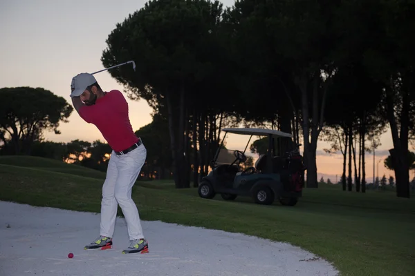 Golfozó üti a homok bunker lövés a sunset — Stock Fotó