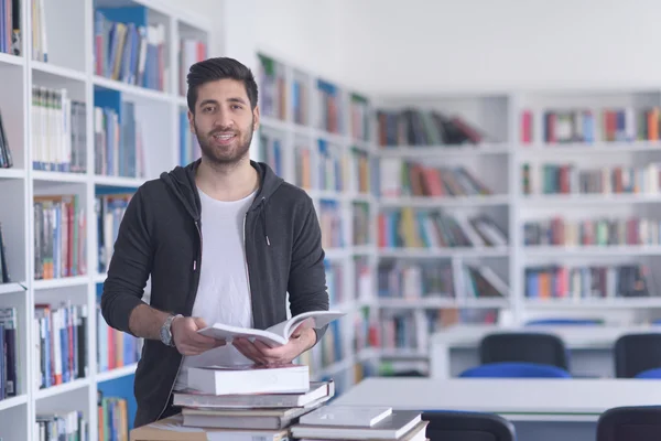 Portrait d'un élève en lisant un livre à la bibliothèque de l'école — Photo