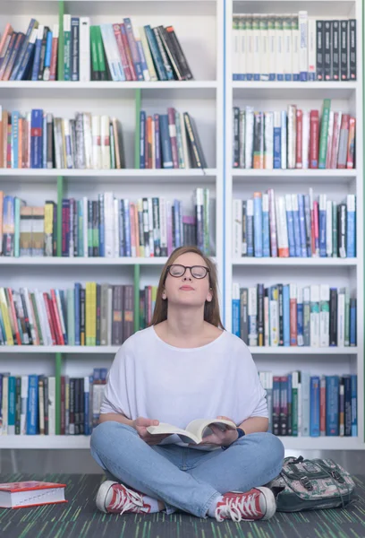 Famale studente lettura libro in biblioteca — Foto Stock