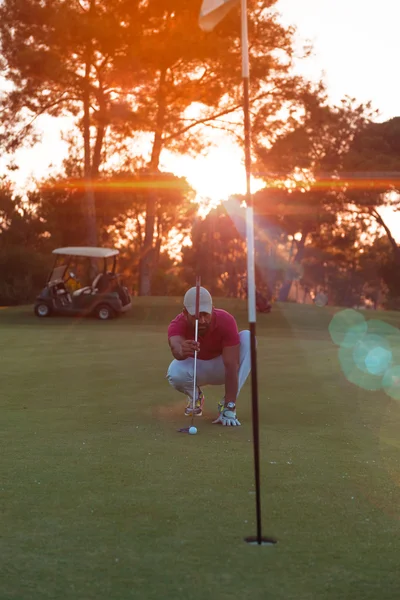 Golfspiller sigter perfekt skudt på smuk solnedgang - Stock-foto