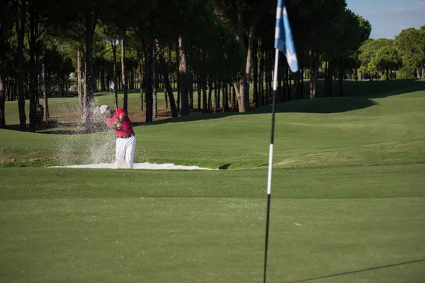 Golfista uderzanie piasku bunkra — Zdjęcie stockowe